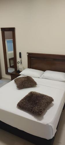 a bedroom with two beds with brown fur pillows at APARTAHOTEL LION in Tuluá