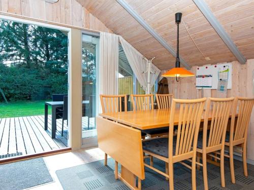 uma sala de jantar com uma mesa de madeira e cadeiras em 4 person holiday home in Oksb l em Øster Vrøgum