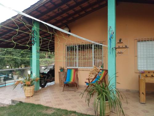 Cette maison dispose d'une terrasse avec deux chaises et une table. dans l'établissement Chácara de Temporada - Mairiporã, à Mairiporã