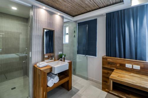 a bathroom with a sink and a shower and a television at Hermosa Wave C2 in Playa Hermosa