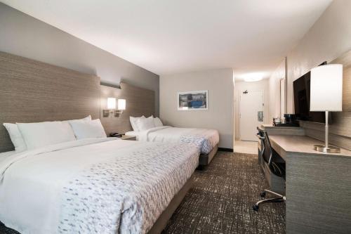 a hotel room with two beds and a flat screen tv at Best Western Plymouth Inn-White Mountains in Campton
