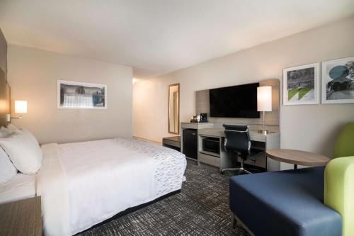 a hotel room with a bed and a desk with a computer at Best Western Plymouth Inn-White Mountains in Campton