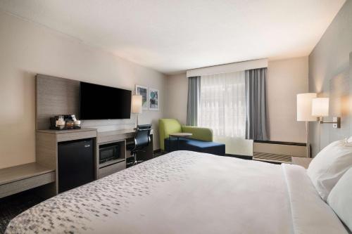 a hotel room with a bed and a flat screen tv at Best Western Plymouth Inn-White Mountains in Campton