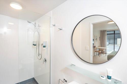 een badkamer met een douche en een spiegel bij The Com Plex Motel in Whakatane