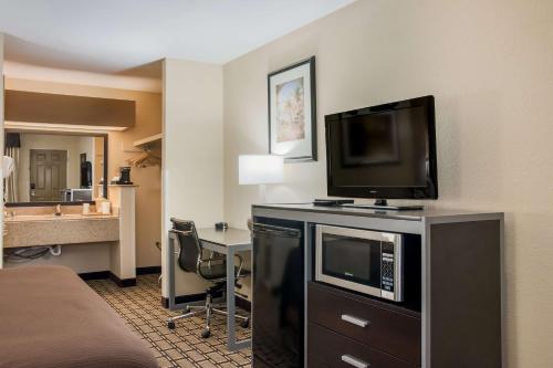 a hotel room with a television and a desk at Best Western Nursanickel Hotel in Dalhart