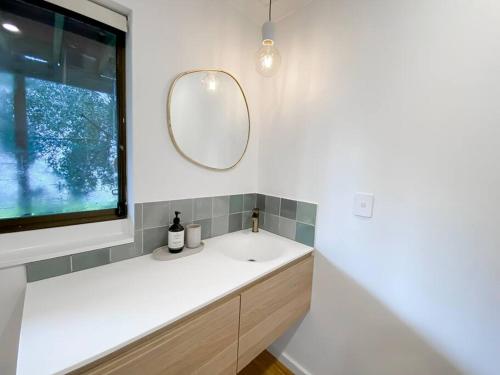 ein Bad mit einem Waschbecken und einem Spiegel in der Unterkunft Mika · Cabin with fireplace, walk to the beach in Dunsborough