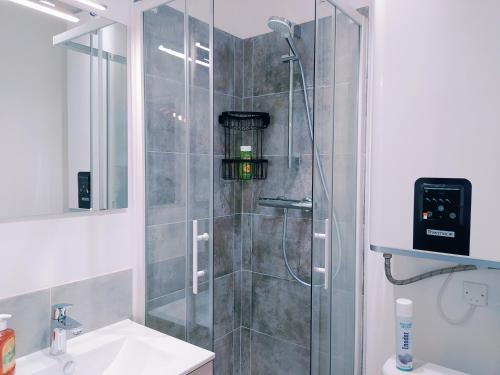 a shower with a glass door in a bathroom at TY NID Studio Rennes HYPERCENTRE HOCHE-ST-ANNE in Rennes