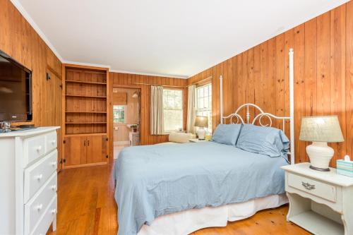 Sonshine Cottage في هيندرسونفيل: غرفة نوم بسرير وجدران خشبية