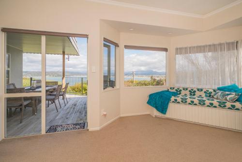 une chambre avec un lit et un balcon avec une table dans l'établissement Hosts on the Coast Harbour Lights, à Whitianga