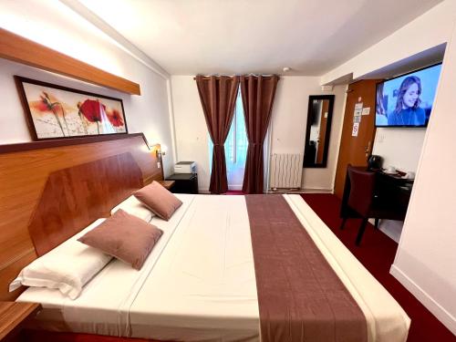 - une chambre avec un grand lit et une télévision dans l'établissement Le Nouvel Hôtel du Théâtre, à Paris
