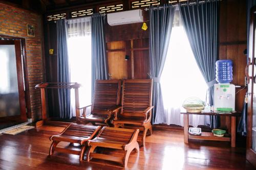 sala de estar con 2 sillas y 2 ventanas en Orangutan Orchard Bungalow, en Timbanglawang