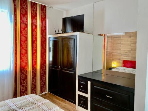 eine kleine Küche mit einem schwarzen Kühlschrank und einem Bett in der Unterkunft Hotel boutique CVC in Acapulco