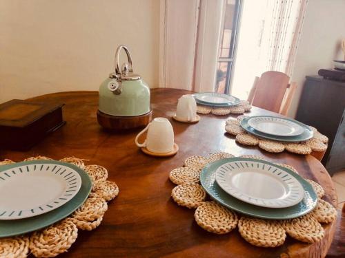 - une table en bois avec des assiettes et une théière dans l'établissement Cafeto Loft Lovely and private loft in Ruta de las Flores heart, à Juayúa