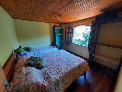 sypialnia z łóżkiem i oknem w obiekcie Casa da Marinda w mieście Visconde De Maua