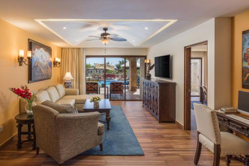 a living room with a couch and chairs and a television at The Residences at Hacienda Encantada in Cabo San Lucas