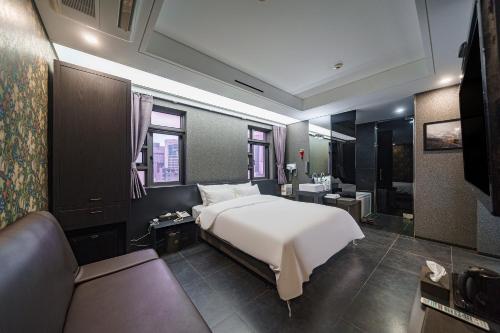 1 dormitorio con cama blanca y sofá en Starhills Hotel, en Seúl