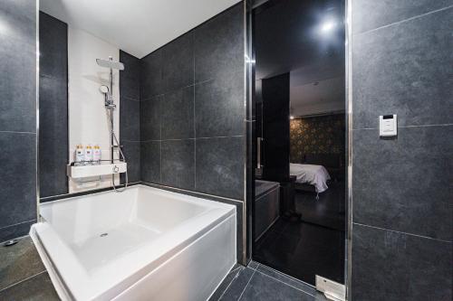 a bathroom with a white tub and a shower at Starhills Hotel in Seoul