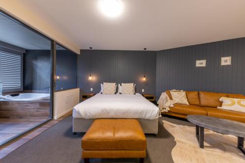 a bedroom with a bed and a couch at Luxury Spa Retreat with Ocean and Hinterland Views in Montville