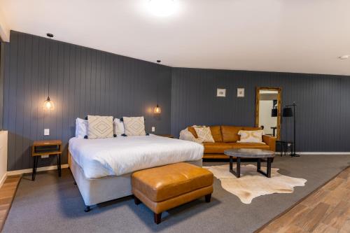 a bedroom with a large bed and a couch at Luxury Spa Retreat with Ocean and Hinterland Views in Montville