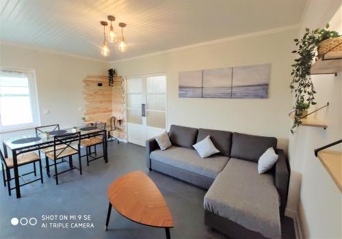 a living room with a couch and a table at Maison des Pommiers - Bord de mer et campagne in Port-en-Bessin-Huppain