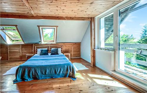 ein Schlafzimmer mit einem Bett in einem Zimmer mit Fenstern in der Unterkunft 3 Bedroom Awesome Home In Suleczyno in Sulęczyno