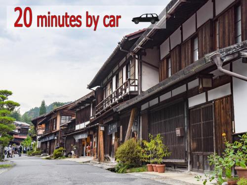 una calle de edificios de madera con las palabras a minutos en coche en 阿寺温泉 フォレスパ木曽あてら荘, en Okuwa