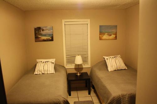 two twin beds in a room with a window at Key West Style Historic Home in Coconut Grove Florida The Yellow House in Miami