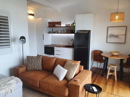a living room with a couch and a kitchen at Saltwater Apartments in Lake Cathie