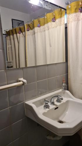 een badkamer met een witte wastafel en een spiegel bij Mendoza R km 0 in Mendoza