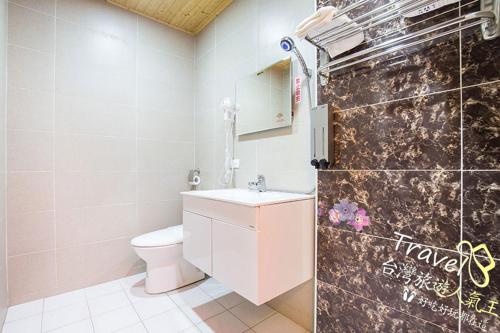 een badkamer met een toilet, een wastafel en een spiegel bij Flowers Blooming Homestay in Jian