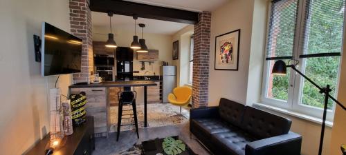 a living room with a couch and a kitchen at villa l'Ambroisine in Lure