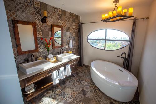 a bathroom with two sinks and a tub and a window at The Residences at Hacienda Encantada in Cabo San Lucas