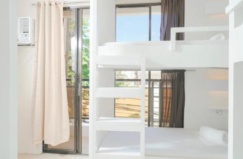een wit stapelbed in een kamer met een raam bij The A Hostel in Boracay