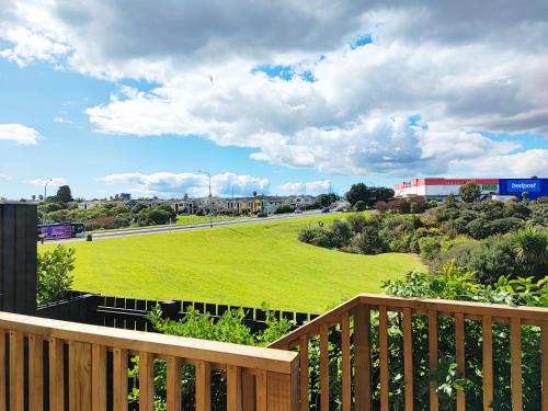 a wooden deck with a view of a green field at Stunning Townhouse - Walking to Botany Shopping Center in Auckland