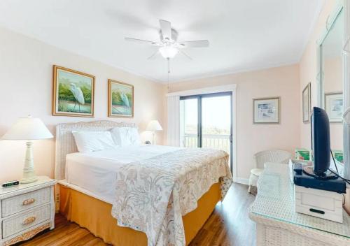 a bedroom with a bed and a television in it at Dunescape Villas by TO in Atlantic Beach