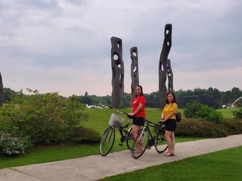 two women standing next to their bikes in front of a sculpture at Friendly villa SH Đại Lải 4 phòng ngủ in Phúc Yên