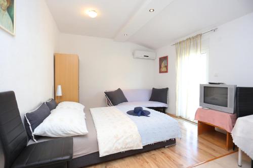 - une chambre avec un lit, une télévision et un canapé dans l'établissement Studio Podstrana 17053b, à Podstrana