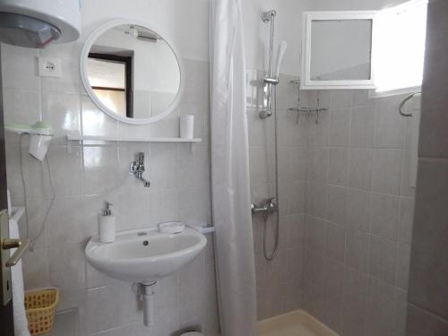 łazienka z umywalką i prysznicem z lustrem w obiekcie Apartments by the sea Okrug Donji, Ciovo - 17078 w mieście Okrug Donji