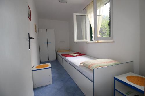 Zastražišće的住宿－Apartments by the sea Cove Vela Stiniva, Hvar - 17075，小房间设有两张床和窗户