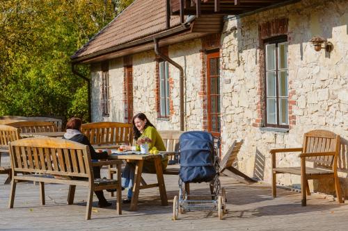 two women sitting at a table on a patio at Karlamuiza Country Hotel in Kārļi