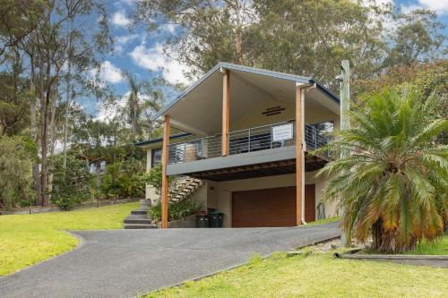 a house with a balcony and a driveway at Clarabelle Cottage in Elizabeth Beach