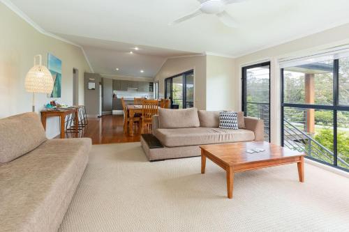 a living room with a couch and a table at Clarabelle Cottage in Elizabeth Beach