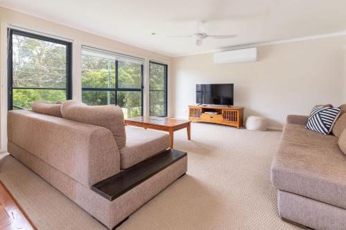 a living room with a couch and a tv at Clarabelle Cottage in Elizabeth Beach