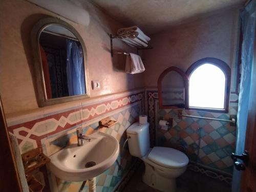 a bathroom with a sink and a toilet and a mirror at Hotel Gernika in Chefchaouene