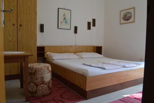 1 dormitorio con cama, mesa y taburete en Apartments by the sea Zivogosce - Mala Duba, Makarska - 17077, en Podgora
