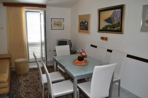 comedor con mesa y sillas blancas en Apartments by the sea Zivogosce - Mala Duba, Makarska - 17077, en Podgora