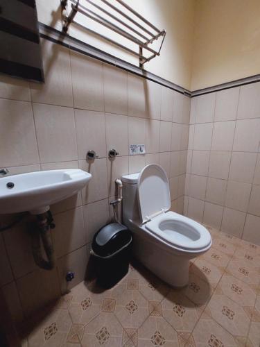 a bathroom with a toilet and a sink at Makabata Guesthouse & Cafe in Manila