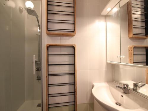 ein Badezimmer mit Waschbecken, Dusche und Spiegel in der Unterkunft Appartement T3 avec terrasse, proche centre et thermes de La Bourboule - FR-1-608-236 in La Bourboule