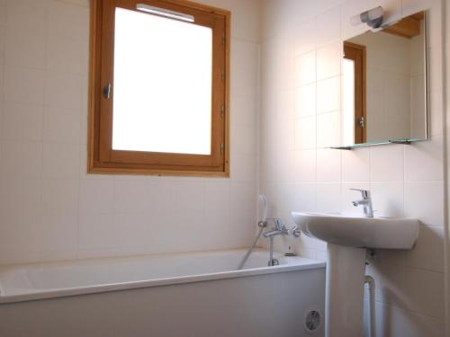 baño con lavabo, bañera y ventana en Chalet Chamrousse, 5 pièces, 8 personnes - FR-1-549-105, en Chamrousse