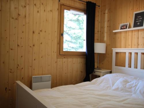 a bedroom with a white bed and a window at Chalet Chamrousse, 5 pièces, 8 personnes - FR-1-549-105 in Chamrousse